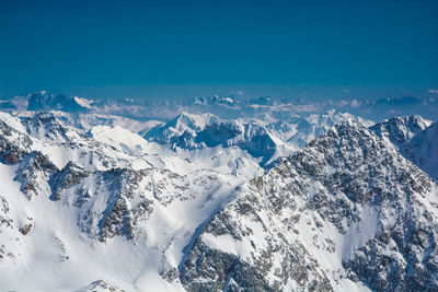 Scenic view of snowcapped mountains against blue sky