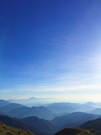 Scenic view of mountains against blue sky