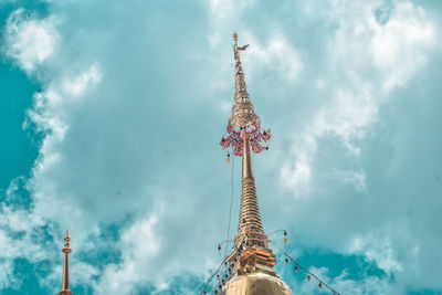 Low angle view of ferris wheel by building against sky