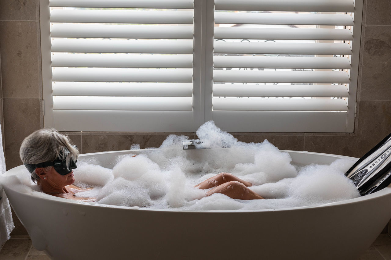 bathtub, domestic bathroom, indoors, bathroom, soap sud, domestic room, bubble bath, taking a bath, home, hygiene, one person, relaxation, lifestyles, white color, leisure activity, day, childhood, window, women