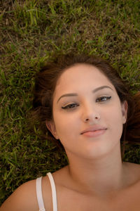 Portrait of young woman lying on lawn