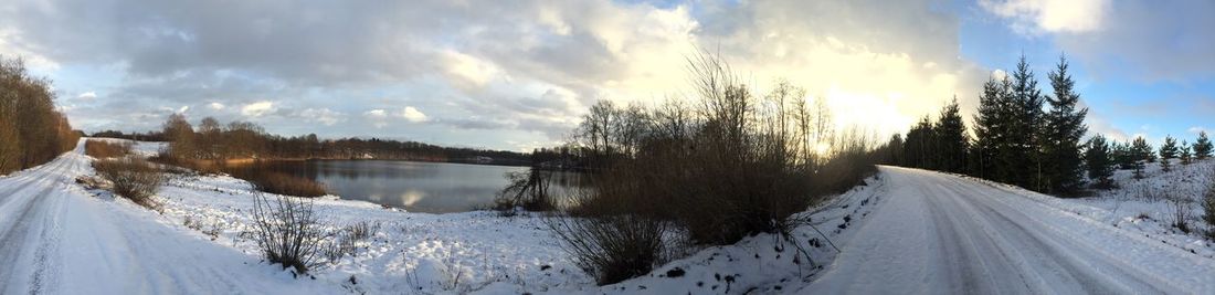 Panoramic view of snow covered landscape against sky