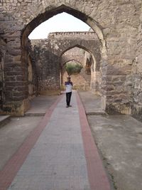 Rear view of woman standing at archway