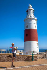 Woman standing against lighthouse