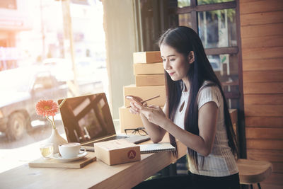 Young woman using mobile phone in cafe