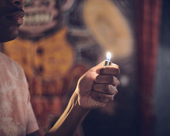 Midsection of man holding lighter