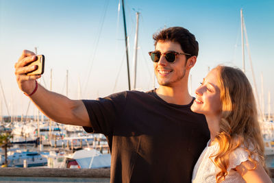 Young couple kissing against sky