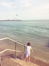 Full length of man standing in sea against sky