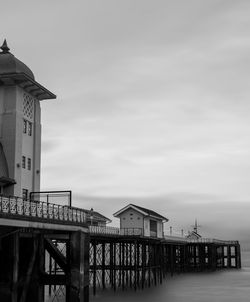 Pier over sea and buildings against sky