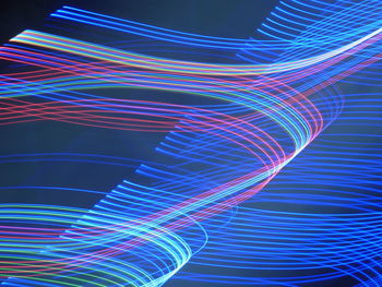 Digital composite image of light trails over black background