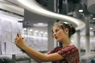 Side view portrait of a young woman holding camera