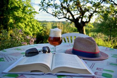 Open book on table against trees