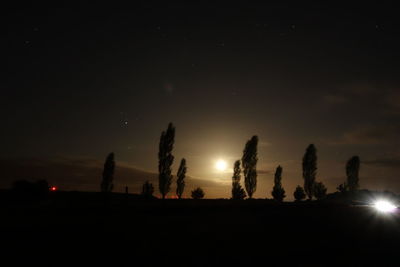 Silhouette trees against sky at night