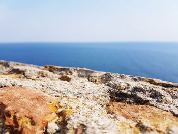 Close-up of rocks in sea against clear sky