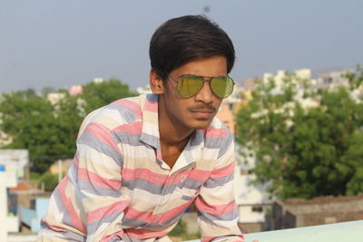 Man standing on building terrace against sky