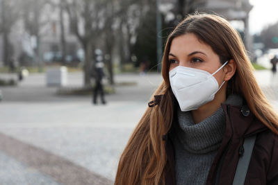 Woman wearing mask sanding on street