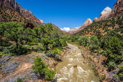 Scenic view of river amidst mountains against clear sky