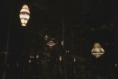 Low angle view of illuminated light bulbs at night