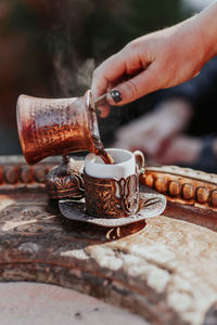 Close-up of hand holding coffee cup