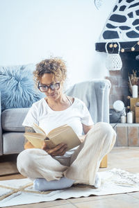 Young woman sitting on sofa at home