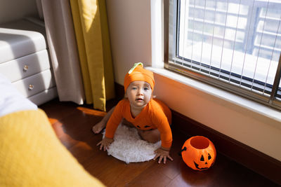 High angle view of girl sitting on floor at home