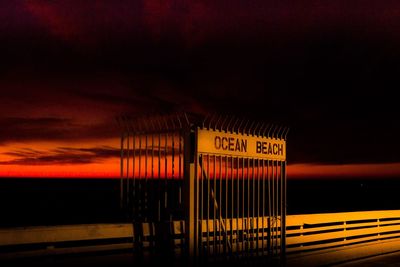 Information sign on beach against sky at night