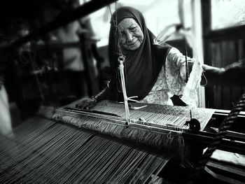 Senior woman weaving loom
