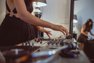 Fashionable young woman playing music at home