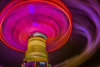 Low angle view of illuminated ferris wheel against sky at night