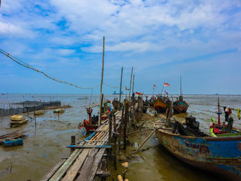 Fishing boat moored at sea against sky