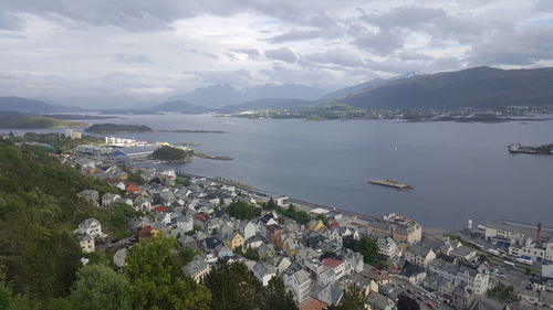 Aerial view of town by sea against sky