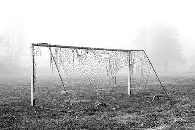 Wooden posts on field against sky