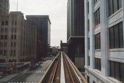 Railroad tracks in city against sky