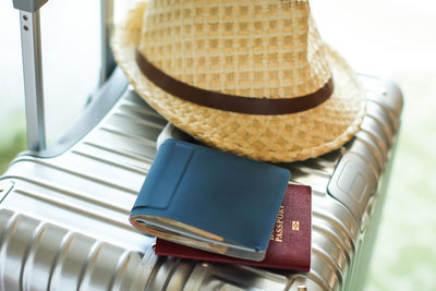 Close-up of hat and wallet with passport on suitcase