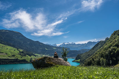 Female on rock at lake lungern, switzerland