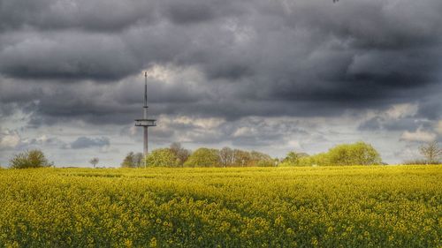 View of field against cloudy sky