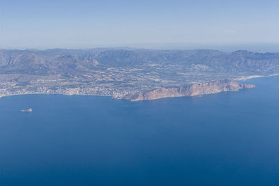 High angle view of sea and mountains against sky