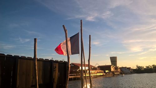 Red flag against built structure against sky