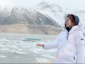 Girl with arms raised on snowcapped mountains