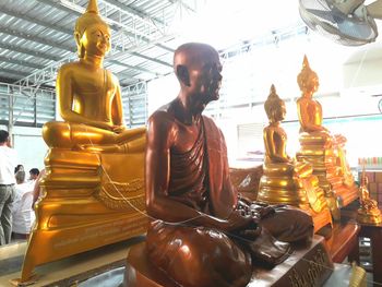 Statue of buddha sitting at temple