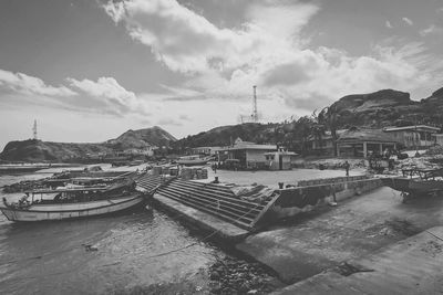 Boats moored at harbor against sky