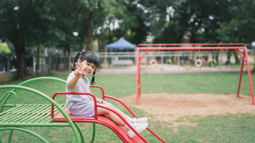 Side view of woman sitting on play equipment