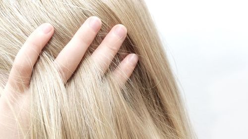 Cropped image of girl with hand in blond hair