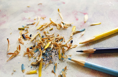 High angle view of colored pencils and shavings on table