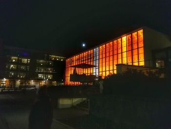 Illuminated city against sky at night