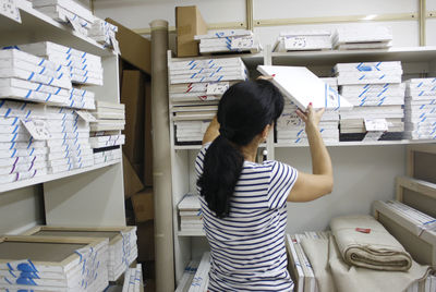 Woman choosing wooden equipment while standing at store