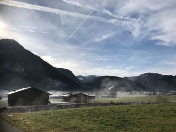 Scenic view of field and mountains against sky