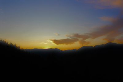 Scenic view of silhouette mountains against sky at sunset