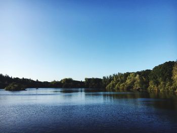 Scenic view of lake against clear blue sky