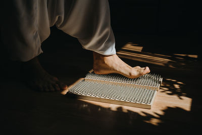 Low section of person standing on sharp boards